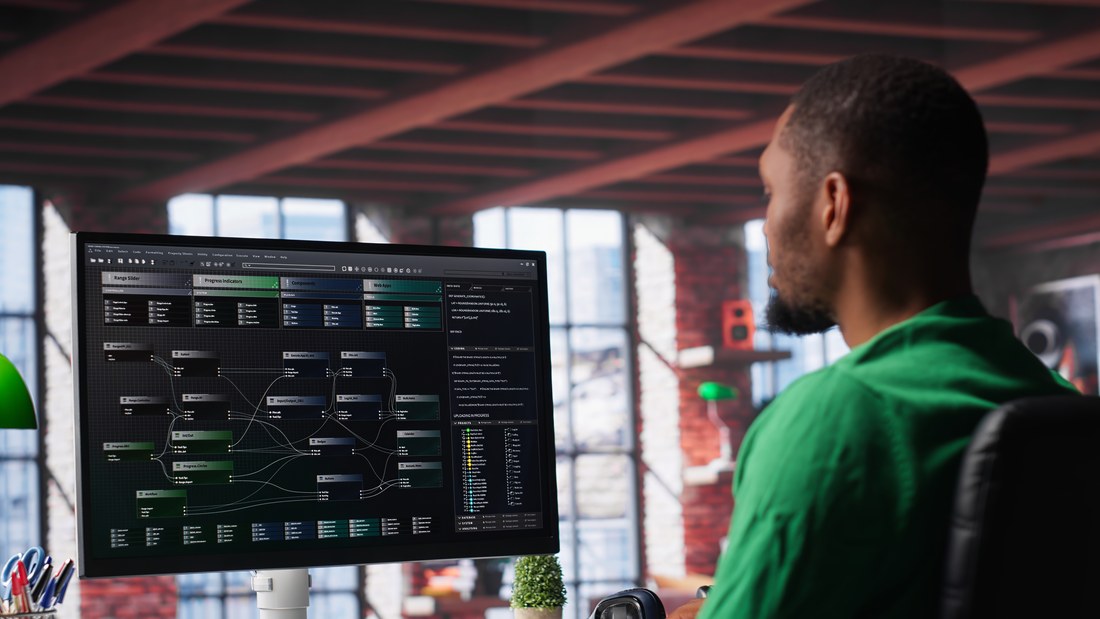 Software developer reviewing a data-flow dashboard on a monitor